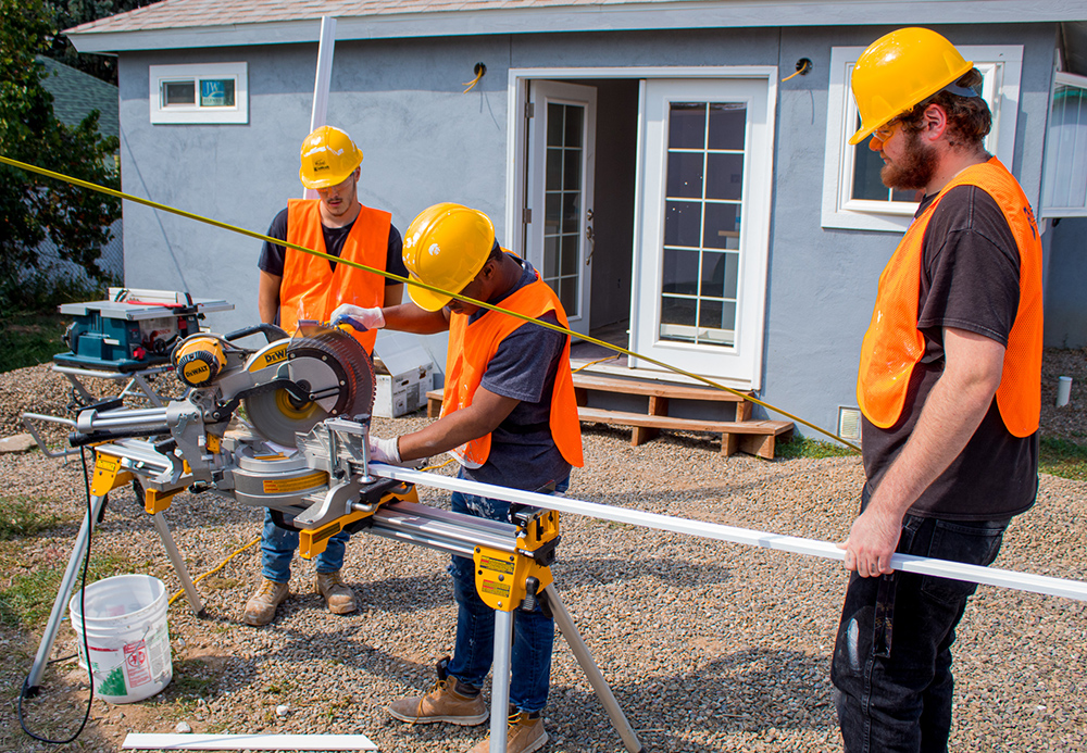 Students at Trinidad State College wear construction gear and work on a house in need of renovation in their community as part of the COPERR program. 