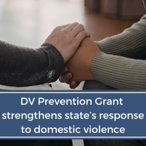One person's hands hold another's in support. Overlayed text says "DV Prevention Grant strengthens state's response to domestic violence"