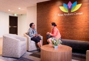 Photo of two women sitting and talking at Rose Andom Center